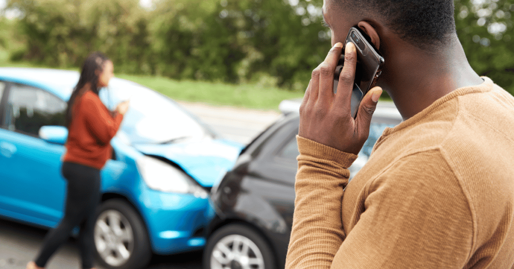 Male driver talking on the phone after a car crash accident.